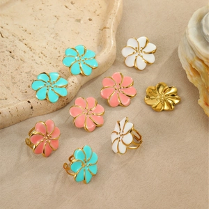 Elegante conjunto de pendientes y anillo de flores en esmalte dorado y pétalos de color
