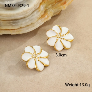 Primer plano de pendientes de flores de esmalte blanco de 3 cm con baño de oro sobre arena
