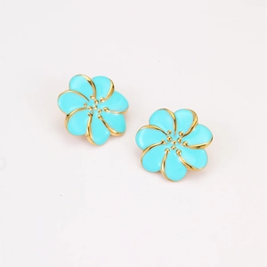 Elegantes pendientes de flores azul tiffany con bordes dorados sobre fondo blanco
