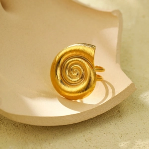Vista dettagliata di un anello a conchiglia a spirale dorato con elegante trama spazzolata