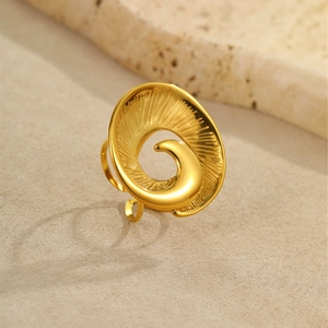 Vista macro dell'anello a spirale dorato in stile marino con finitura metallica fine