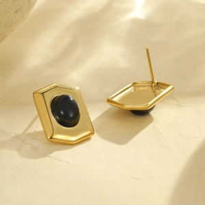 Makroaufnahme von 18K vergoldeten geometrischen Ohrringen mit schwarzem Onyx