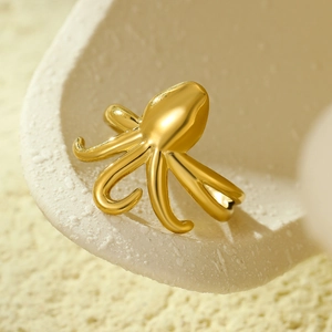 Dettaglio macro di anello a tentacolo di polpo dorato con finitura metallica lucida
