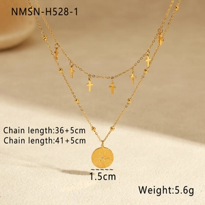Gros plan d'un collier double rang en acier titane doré avec croix et médaille étoile