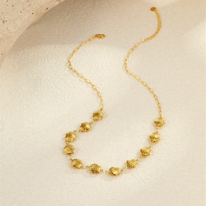 Détail du collier plaqué or 18 carats avec coquillages creux et fermoir mousqueton
