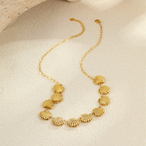 Détail du collier étoile de mer doré 18 carats montrant les charmes de coquillages