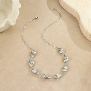 Détail du collier argenté étoile de mer et coquillage avec pendentifs texturés