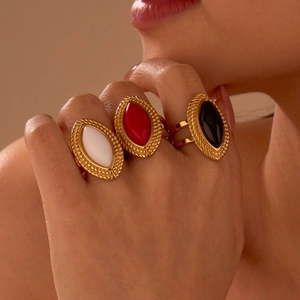Nahaufnahme goldener Vintage-Ringe mit ovalem Achat in Rot, Schwarz und Weiß mit Seilrand