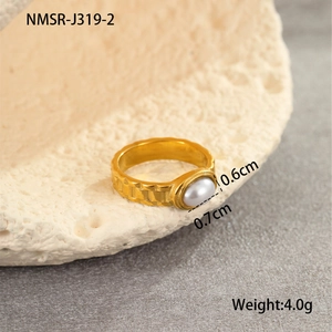 Detail of a gear textured titanium steel ring with a 0.7cm oval pearl on a stone prop