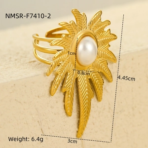 Detalle de un anillo dorado vintage con diseño de hoja solar e incrustación de perla