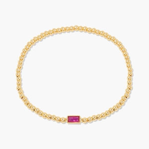 Détail d'un bracelet en perles dorées 18 carats avec zircon rectangulaire rose rouge