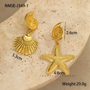 Detail of gold seashell and starfish earrings set on stone with size measurements