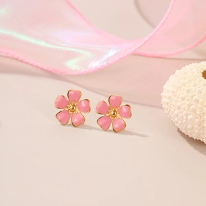 Close-up of pink flower earrings with gold edges and soft ribbon background