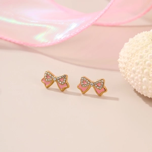 Close-up of pink enamel bow earrings with gold plating and sparkling crystals
