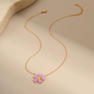 Close-up of golden O-chain necklace featuring a purple enamel flower charm with lobster clasp
