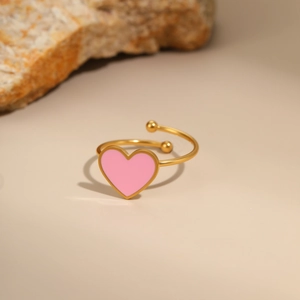 Detail of adjustable golden ring with heart-shaped pink enamel and small gold beads