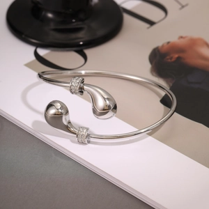 Detailed close-up of a silver teardrop cuff bracelet featuring elegant micro-inlaid crystals