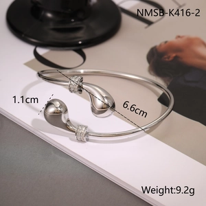 Detail view of silver teardrop bangle with pavé settings and size measurement labels