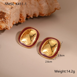 Detail of vintage French gold earrings with hammered texture and deep red enamel