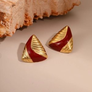 Macro shot of gold stainless steel triangle earrings with deep red enamel and retro texture