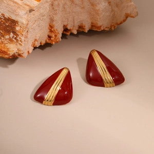 Detail of vintage French style triangular earrings with deep red glaze and gold stripes
