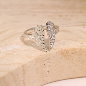 Macro shot of silver titanium steel ring featuring detailed hammered texture and wing design