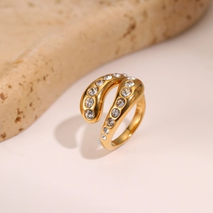 Detailed macro view of wrap-around gold ring with sparkling white zircon stones