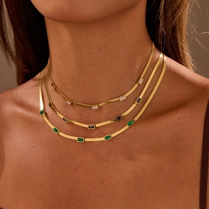 Gros plan sur le collier à trois couches en or avec des pierres de zircon colorées