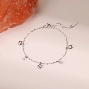 Detailed close-up of a silver star charm bracelet with sparkling zircon stones