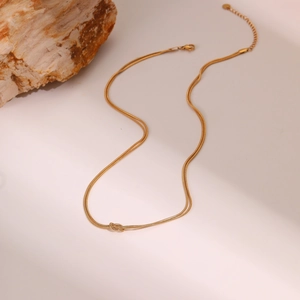 Dubbellaagse gouden slangenketting met centraal knoopontwerp en verlengstuk ketting