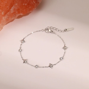 Macro shot of silver titanium bracelet with star pendants and round zircon accents
