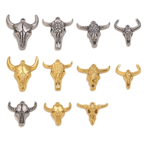 Vista dettagliata di vari ciondoli a teschio di toro in oro e argento antico per gioielli fai da te