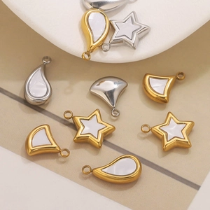 Macro detallada de colgantes de concha en oro y plata con formas de estrella y gota