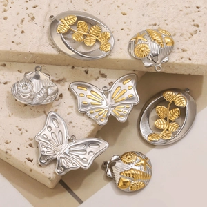Collection de pendentifs en acier inoxydable avec papillons et coquillages sur pierre beige