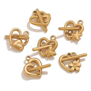 Macro detail of heart-shaped 18k gold-plated OT toggles in various motifs for DIY jewelry