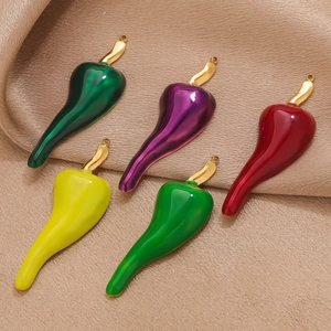Set of five colorful stainless steel chili pepper pendants on elegant champagne satin fabric