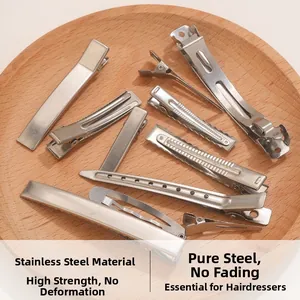 Macro shot of stainless steel salon hair clips with various textures on a wooden tray
