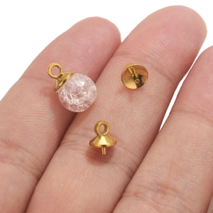 Macro shot of gold plated cone bead cap connector with clear crackle glass bead charm