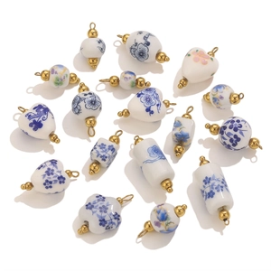 Dettaglio di ciondoli assortiti in porcellana blu e bianca con cappucci dorati DIY