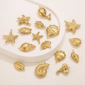 PVD gold plated stainless steel sea life charms on a white stone tray display