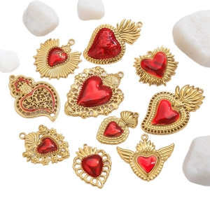 Sacred heart pendants in 18k gold plated stainless steel on white pebbles