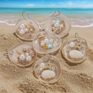 Macro detail of 6 ocean-themed resin pendants with starfish and shells on a sandy beach
