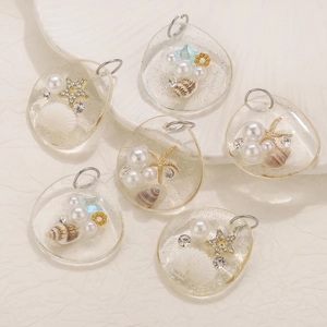 Detailed macro view of resin pendants featuring seashells, pearls, and golden ocean charms