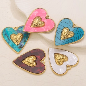 Cinq pendentifs cœur en plaqué or 18k avec émail coloré sur un plateau blanc