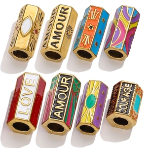 Macro view of gold stainless steel hexagonal beads with colorful enamel boho patterns