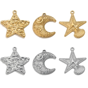 Detail of gold and silver star and moon pendants with textured stainless steel surfaces