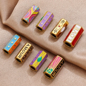 Colorful hexagonal stainless steel enamel beads with gold finish on silk background