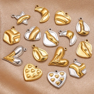 Detailed view of bicolor heart and moon pendants in gold and silver stainless steel