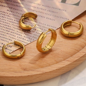 Classic 18K gold plated thick hoop earrings set on a minimal wooden tray display