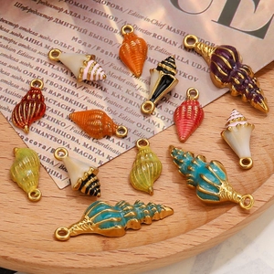 Détail de pendentifs coquillages émaillés colorés avec finition dorée pour bijoux